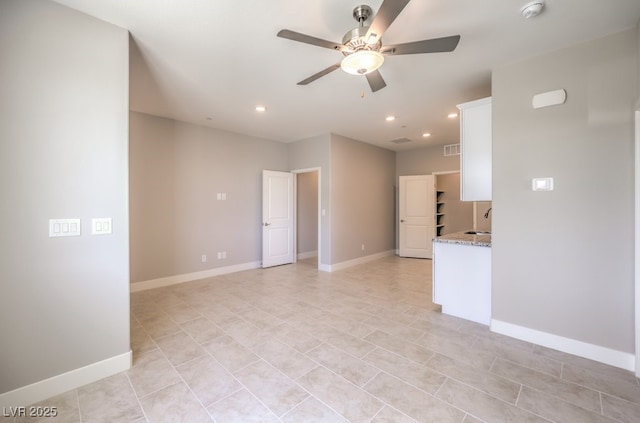 tiled empty room with ceiling fan and sink