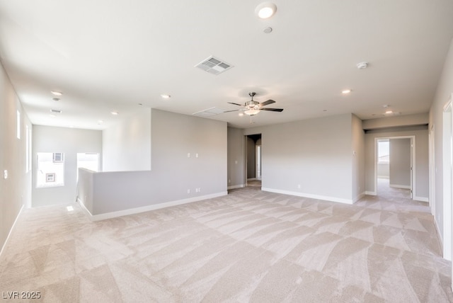 empty room featuring ceiling fan and light carpet