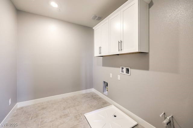 washroom with washer hookup, cabinets, light tile patterned floors, and hookup for an electric dryer