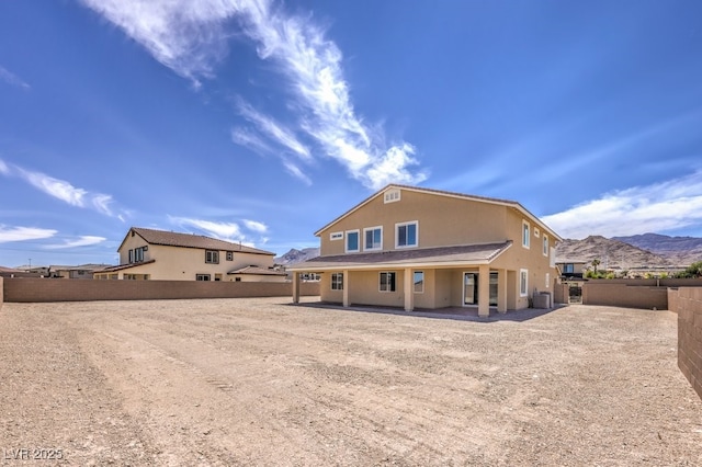 rear view of property with central AC unit and a mountain view