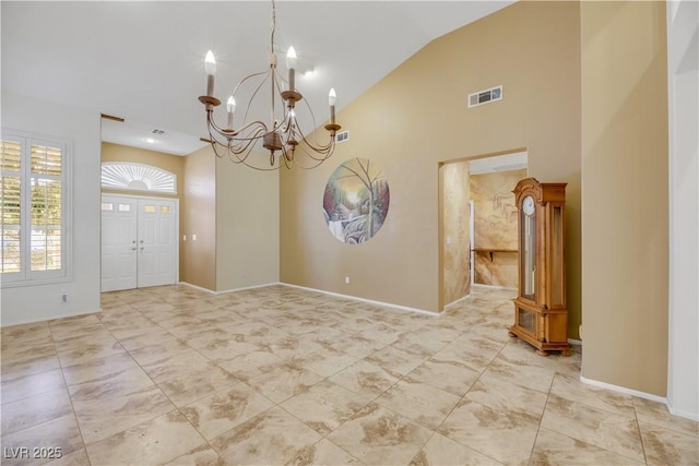 entryway with high vaulted ceiling and an inviting chandelier