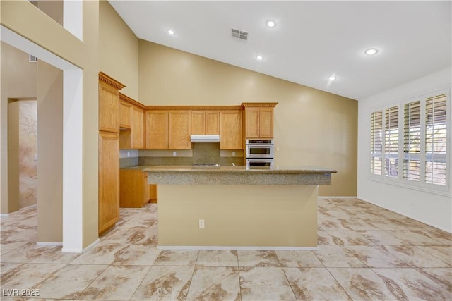 kitchen featuring tasteful backsplash, a center island with sink, stainless steel double oven, and high vaulted ceiling