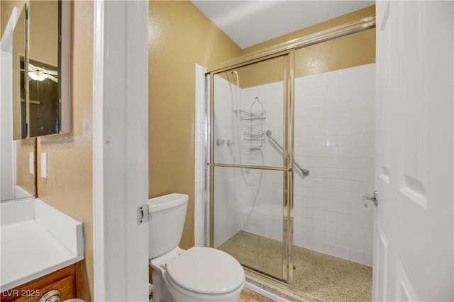 bathroom featuring toilet, a shower with shower door, and vanity