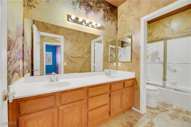 full bathroom featuring toilet, bath / shower combo with glass door, and vanity