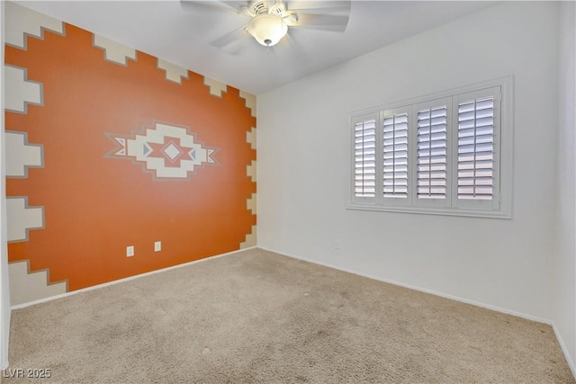 empty room featuring ceiling fan and carpet