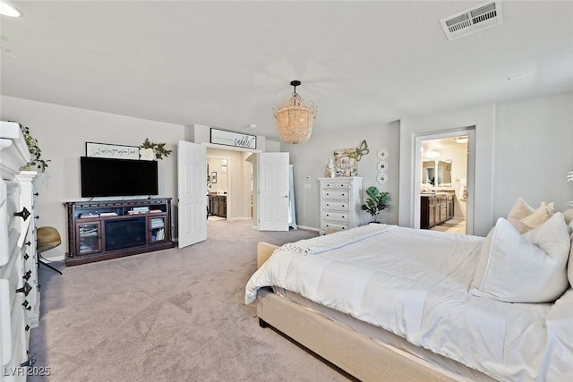 bedroom with light carpet and ensuite bath