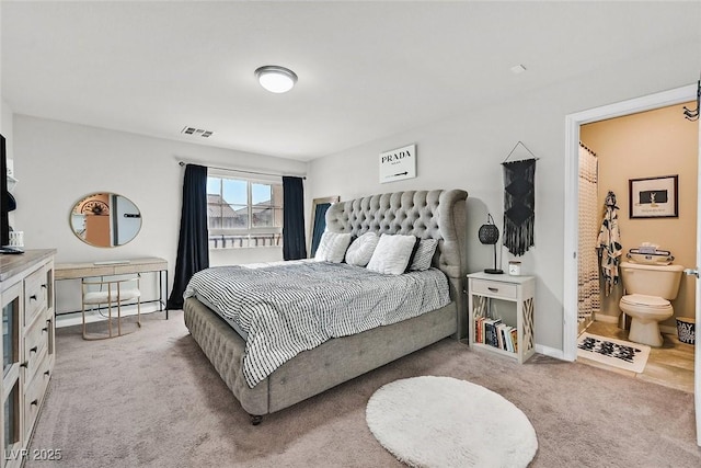 bedroom featuring light colored carpet and ensuite bathroom