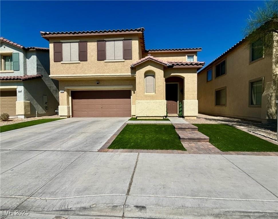 mediterranean / spanish house with driveway, a tiled roof, an attached garage, and stucco siding