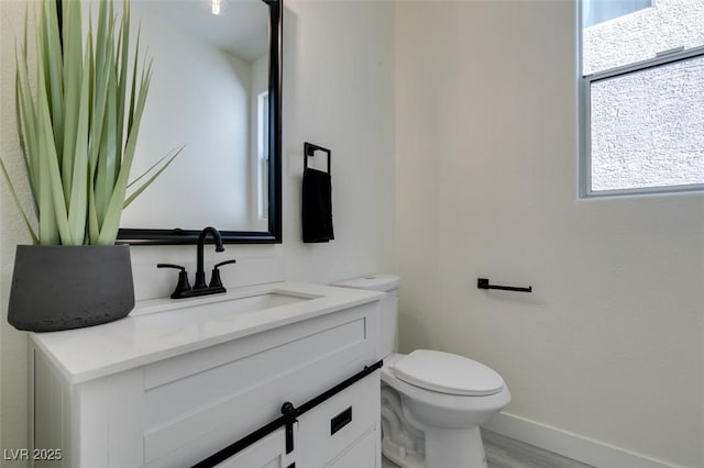 bathroom featuring toilet, hardwood / wood-style flooring, and vanity