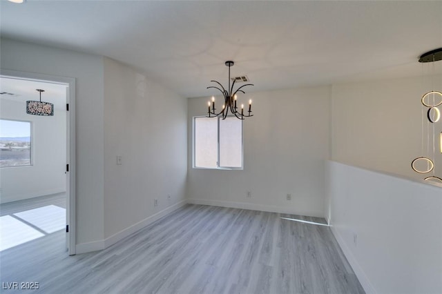 unfurnished dining area featuring a chandelier and light hardwood / wood-style floors