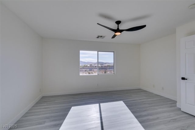 empty room featuring hardwood / wood-style flooring and ceiling fan