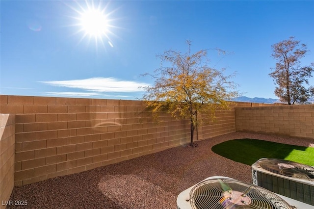 view of yard with central AC and a mountain view