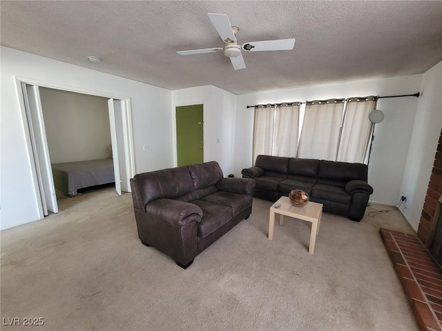 living room featuring light carpet, ceiling fan, a fireplace, and a textured ceiling