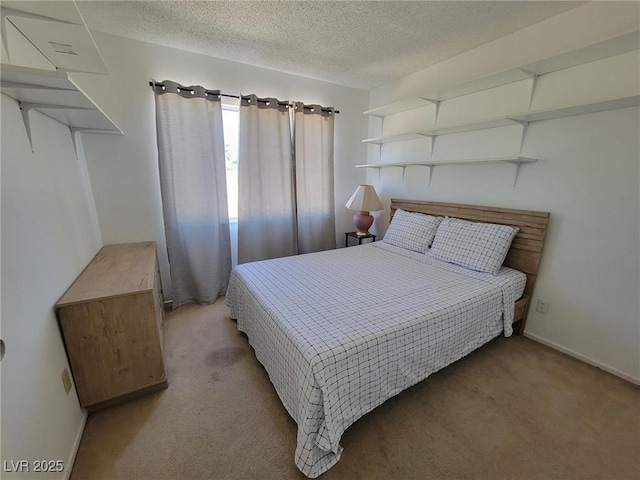 bedroom featuring a textured ceiling and light colored carpet