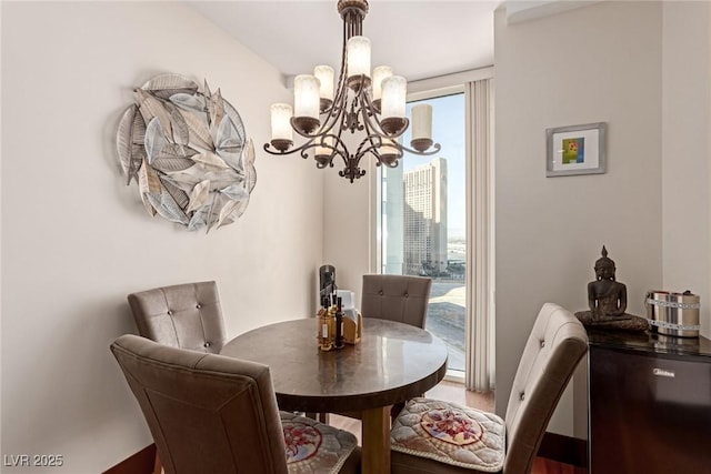 dining space with wood-type flooring and an inviting chandelier