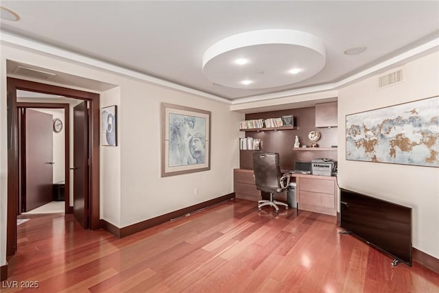 office featuring light hardwood / wood-style flooring and built in shelves