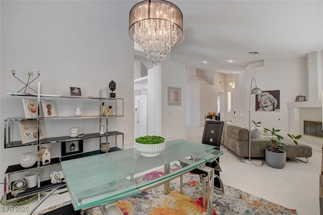 carpeted dining space with an inviting chandelier