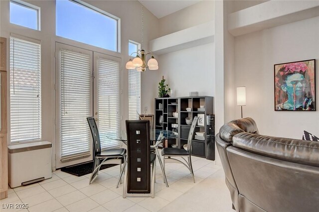 dining area featuring light tile patterned floors, a healthy amount of sunlight, and an inviting chandelier