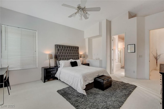 bedroom featuring ceiling fan, connected bathroom, light carpet, and lofted ceiling