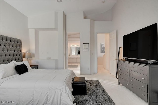 carpeted bedroom with vaulted ceiling and ensuite bath