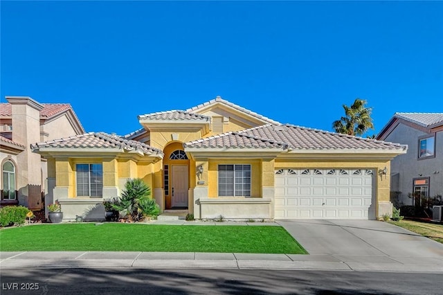 mediterranean / spanish house with a front yard and a garage