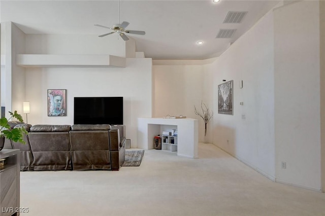 carpeted living room with ceiling fan