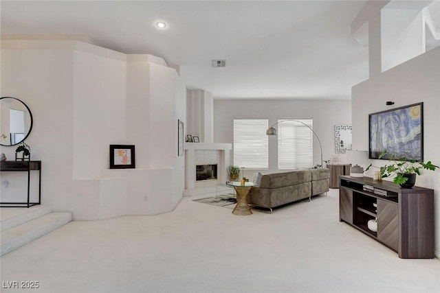 living room with light colored carpet and a tile fireplace