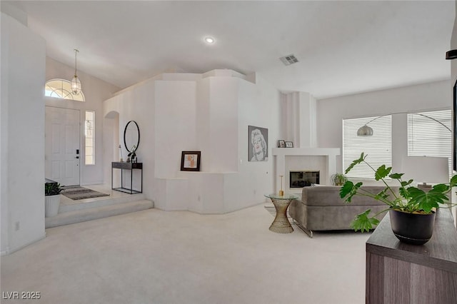 carpeted living room featuring vaulted ceiling