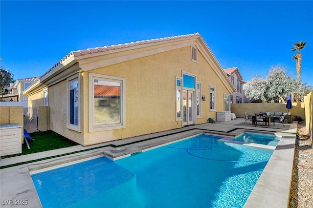 back of property featuring a fenced in pool and a patio