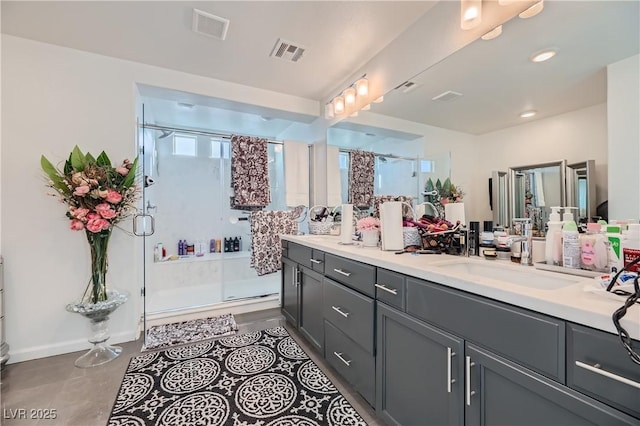 bathroom featuring vanity, a shower with shower door, and tile patterned flooring