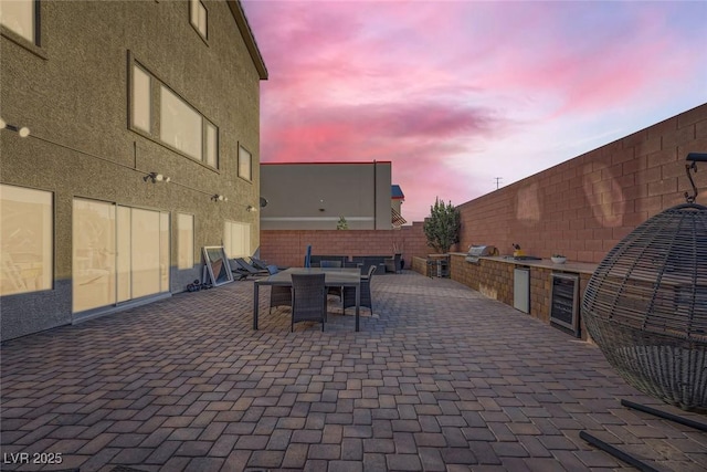 patio terrace at dusk with grilling area and wine cooler