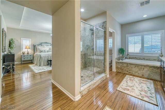 bathroom with independent shower and bath, wood-type flooring, and toilet