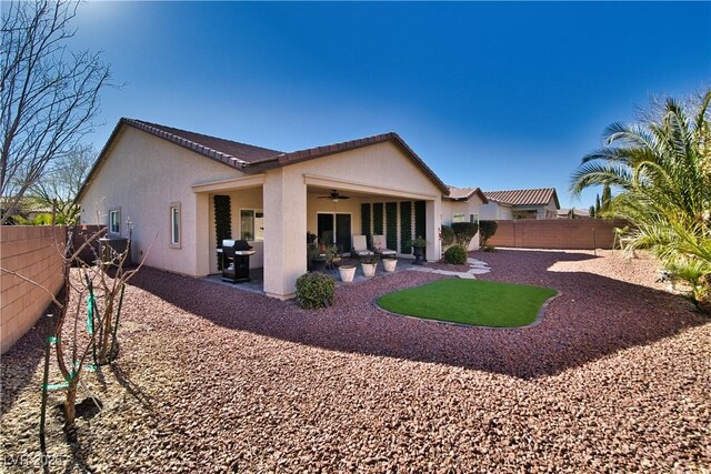 back of property with ceiling fan and a patio