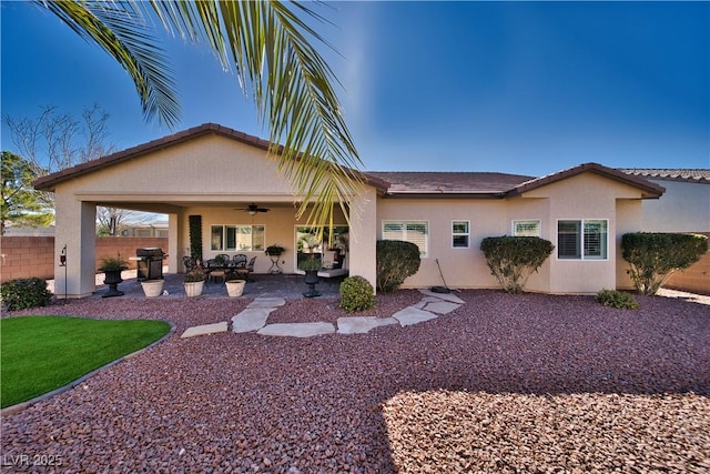 rear view of property featuring ceiling fan, a patio, fence, and stucco siding