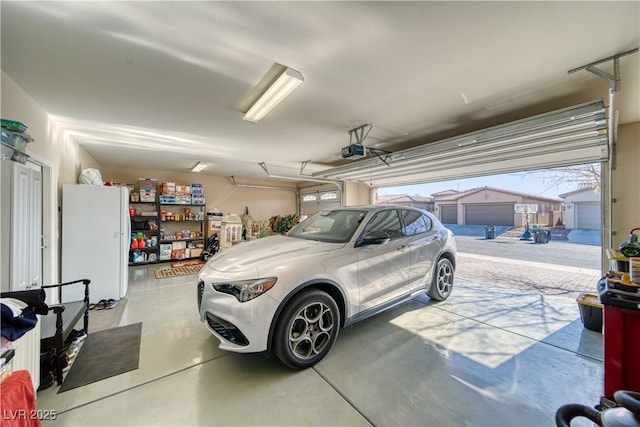 garage with a garage door opener and white fridge