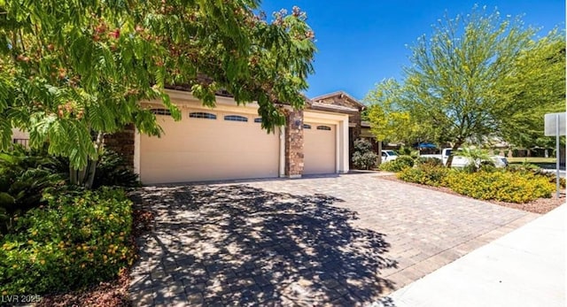 view of front facade with stone siding, decorative driveway, and a garage