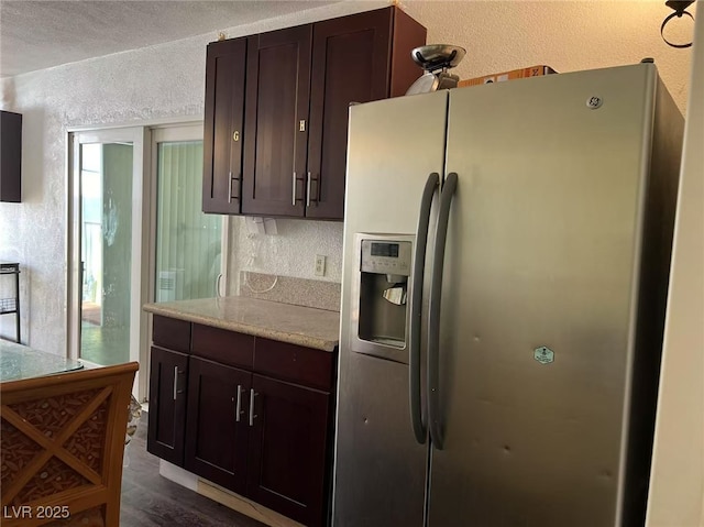 kitchen featuring dark wood-type flooring, a textured ceiling, stainless steel fridge with ice dispenser, and dark brown cabinets