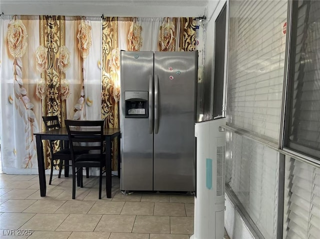 kitchen with light tile patterned floors and stainless steel fridge