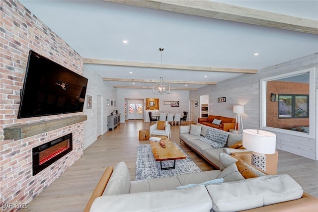 living room featuring light hardwood / wood-style flooring, beamed ceiling, and an inviting chandelier