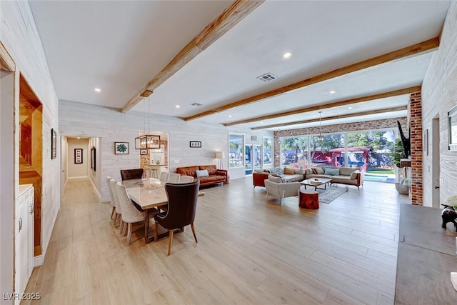 dining room featuring light wood-type flooring and beamed ceiling