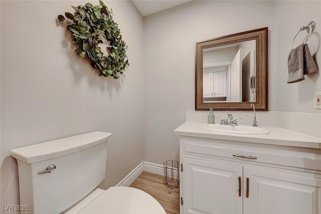 bathroom featuring toilet, hardwood / wood-style flooring, and vanity