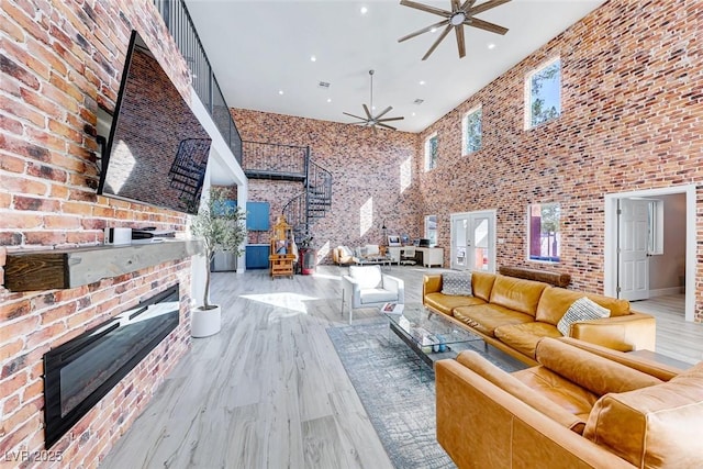 living room featuring a fireplace, a towering ceiling, and hardwood / wood-style floors