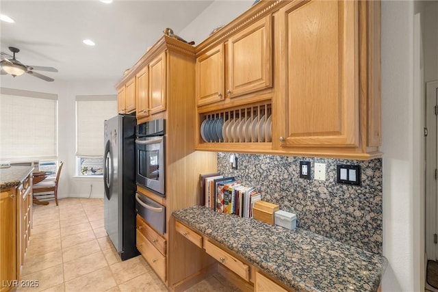 kitchen featuring stainless steel appliances, tasteful backsplash, dark stone countertops, ceiling fan, and light tile patterned floors