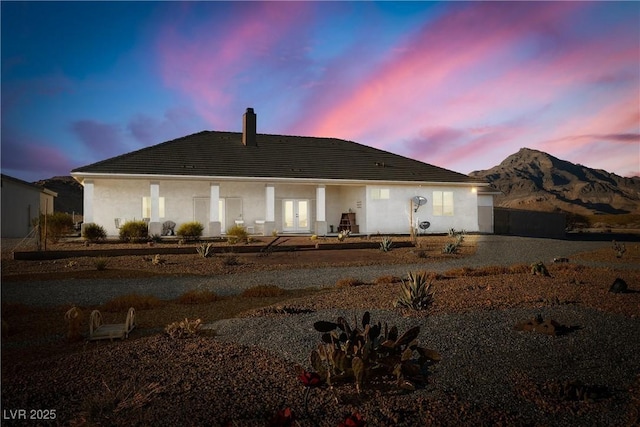 back house at dusk with a mountain view