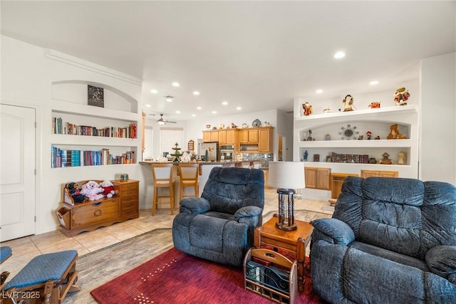 tiled living room featuring ceiling fan and built in shelves