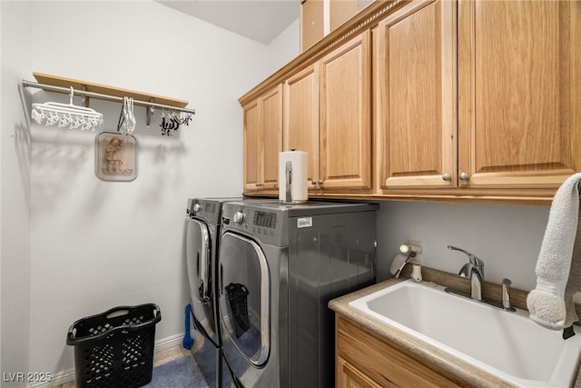 clothes washing area with cabinets, sink, and independent washer and dryer