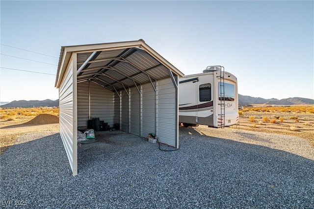 view of outdoor structure featuring a mountain view and a carport