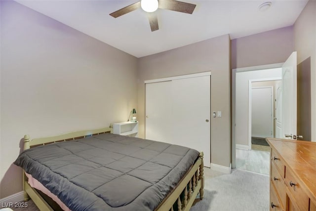 bedroom featuring ceiling fan, light colored carpet, and a closet