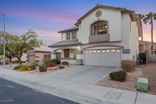 mediterranean / spanish home with a garage and central AC