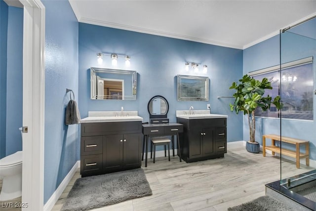 bathroom with wood-type flooring, toilet, vanity, and crown molding